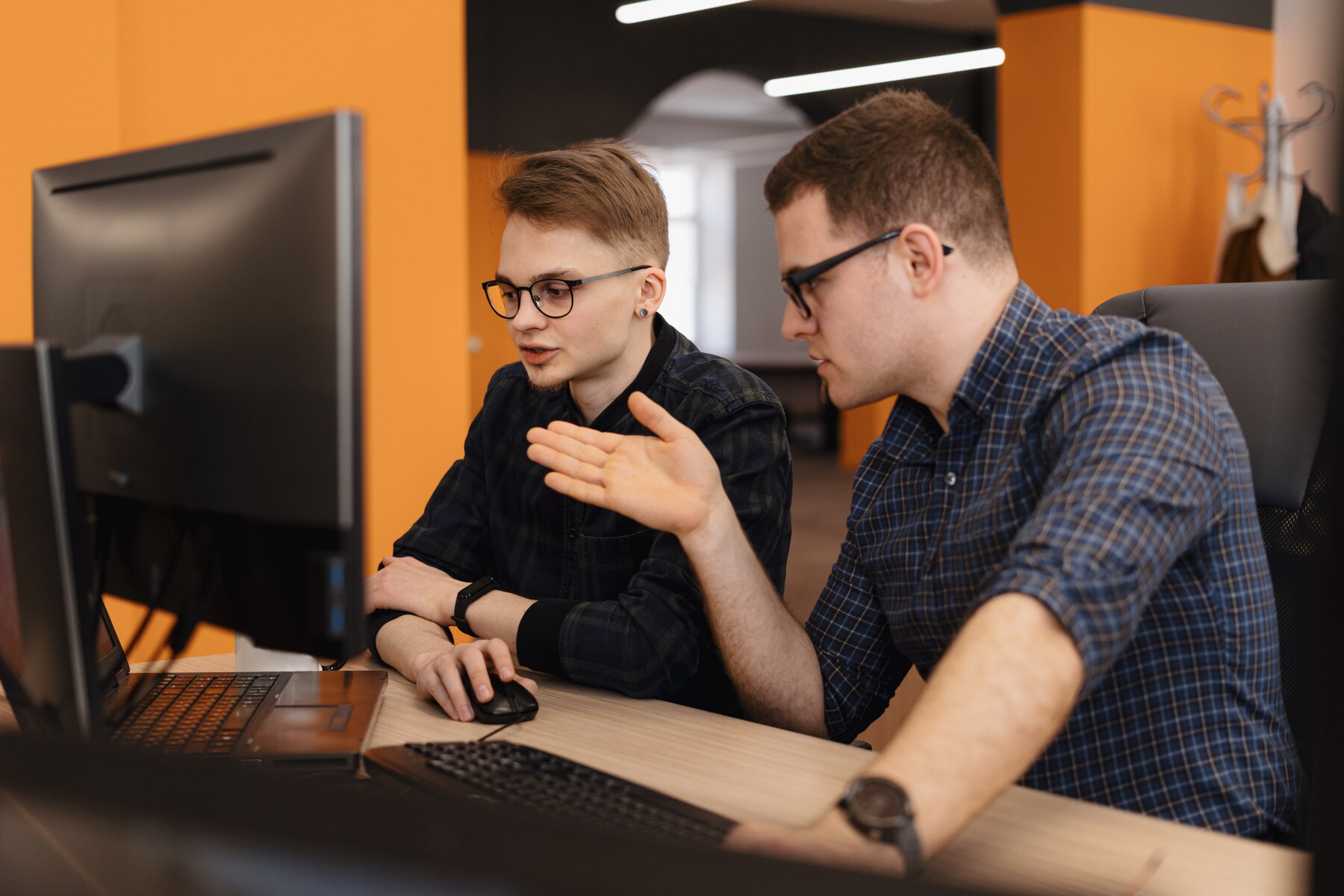 Discussion entre deux développeurs intégrateurs dans un bureau